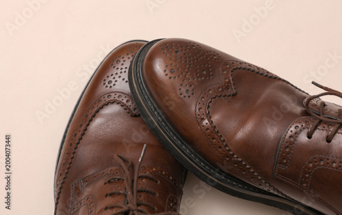 Fotografie Man's Classic leather brown brogue shoes on a beige background