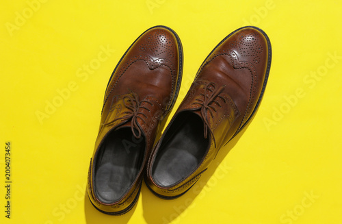 Canvas Print Man's Classic leather brown brogue shoes on a yellow background