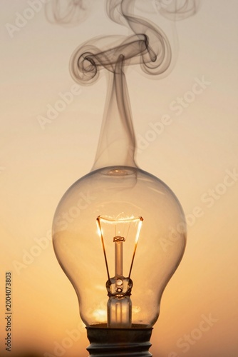 Imagine an ultra close up of a vintage style light bulb, its glass surface glowing softly with a warm