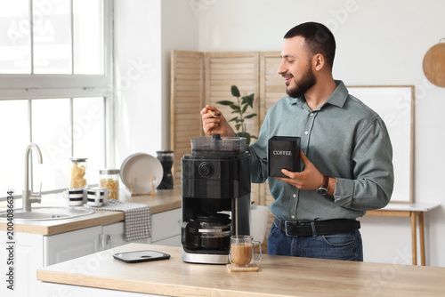 Young man using coffee mach...