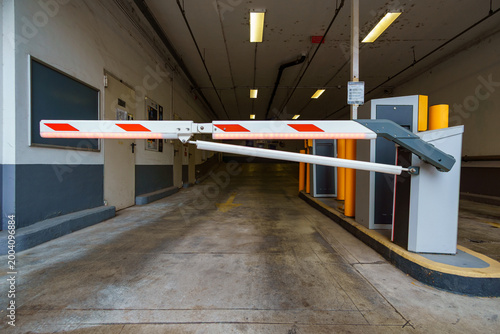 Automatic barrier gate arm closed at an underground parking garage entrance in Budapest, Hungary, providing security and access control to a private vehicle parking lot.