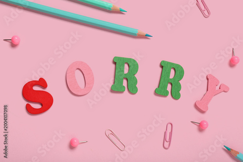 Canvas Print Pencils and word SORRY made from colorful letters on pink background