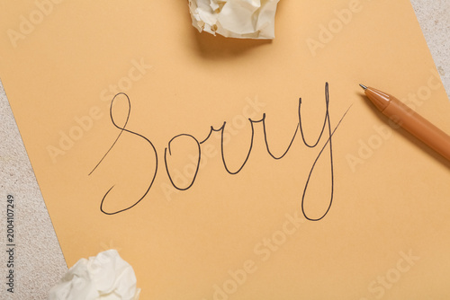 Photography Sheet of paper with word SORRY and crumpled papers on white grunge background