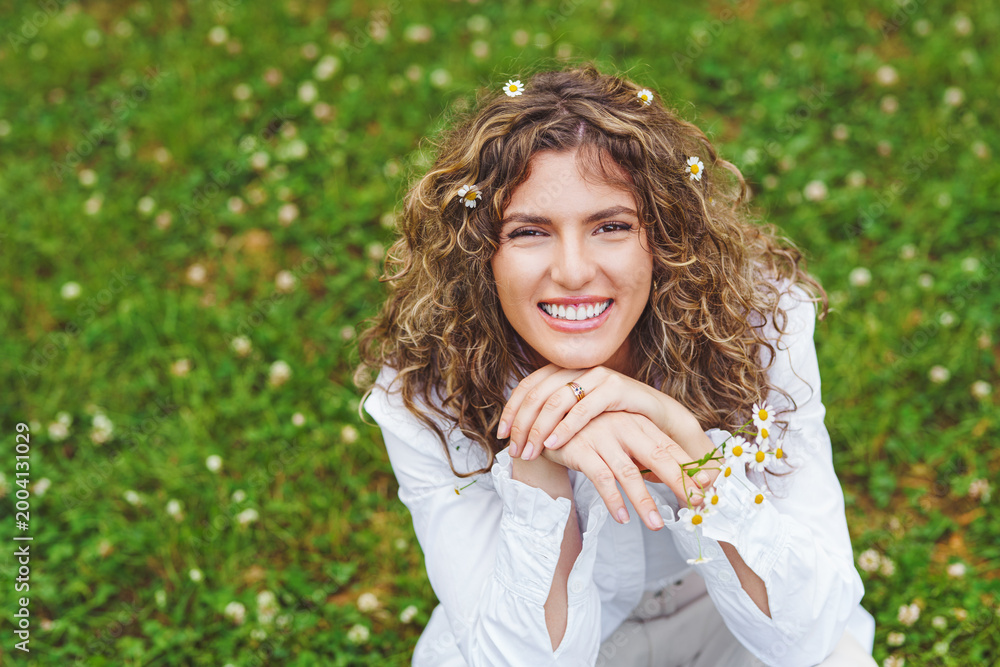Naklejka premium Pretty smiling authentic girl relaxing outdoor in summer by sunlight.