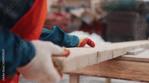 Cutting wooden board with circular saw during construction work close up