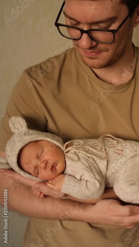 father with a newborn baby, happy parents and a baby, dad hugging and kissing the baby while holding it in his arms, happy single father