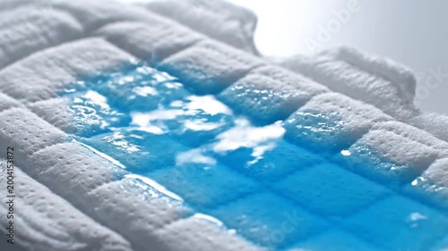 Absorbent Pad with Blue Liquid Dropping and Spreading, Close-up