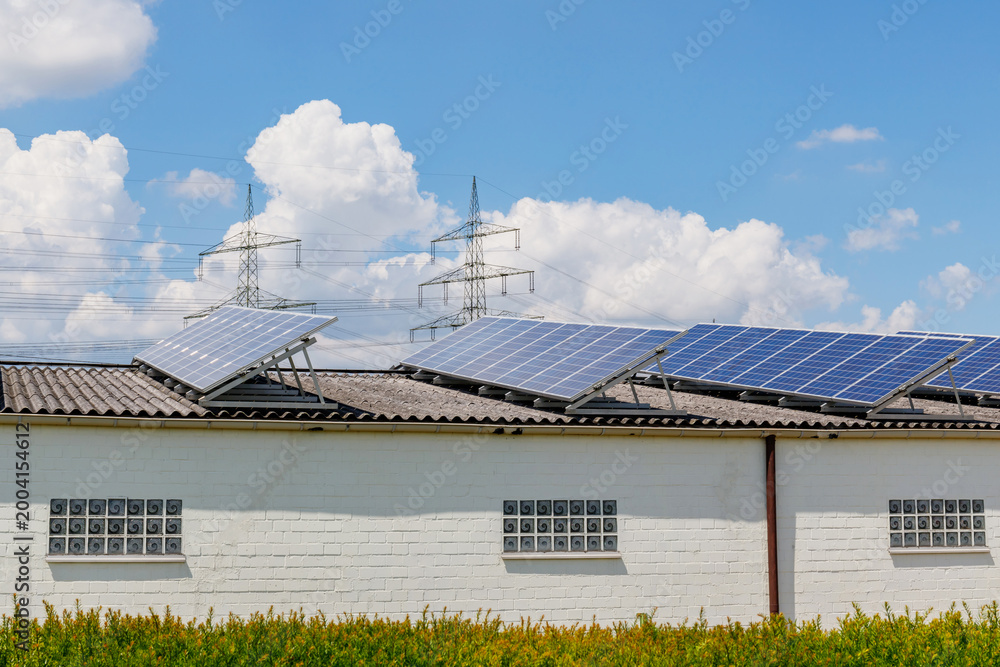 Obraz premium Solar panels on a roof with power lines and a blue sky in the background during the day