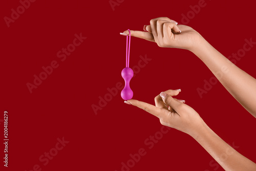 Woman with anal plug on red...
