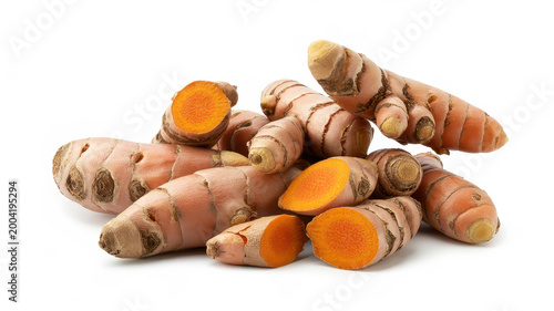 Fresh turmeric roots with sliced pieces showing bright orange interior on a white background