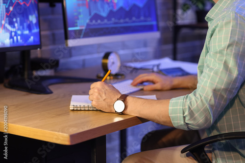Male trader with notebook w...