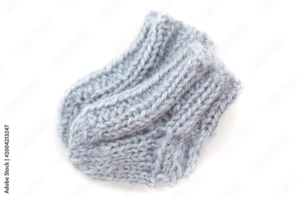 Fototapeta premium Knitted gray baby socks placed on a white background are ready for use in everyday wear