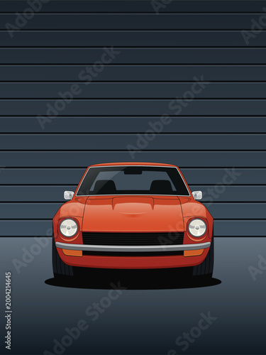 Orange sports car shown from the front in a dark modern garage with dramatic lighting