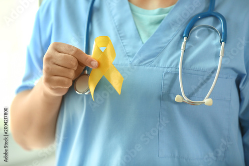 Doctor holding yellow ribbo...