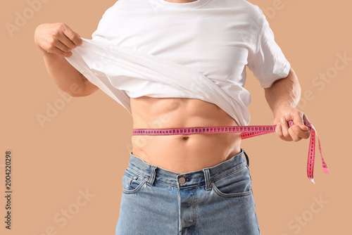 Male bodybuilder measuring ...