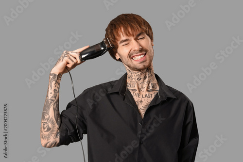 Young tattooed barber with ...