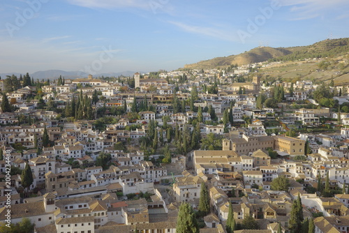 Aerial Panoramic View of Granada Albaicin Historic District with White Houses, Cypress Trees, Church Towers and Hills in Warm Golden Light, Andalusia Spain