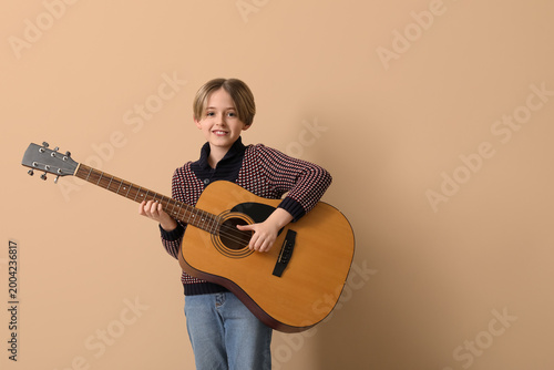 Cute little boy plying guit...