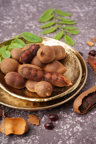 Obraz na plátně Plates of tasty tamarinds on grey background