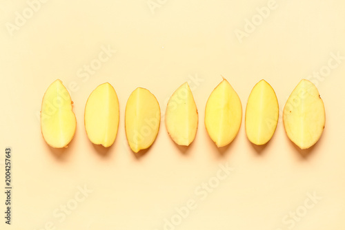 Bild auf Leinwand Pieces of raw potatoes on yellow background