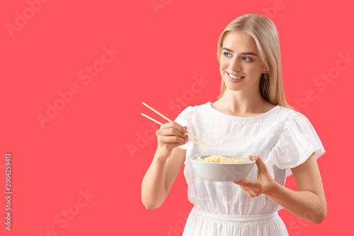Young woman eating noodles ...