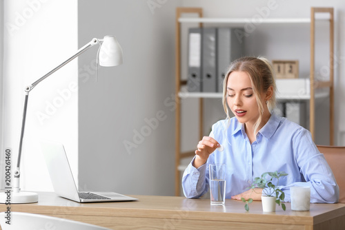 Young businesswoman putting...