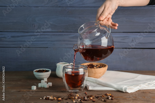 Woman pouring fruit tea fro...