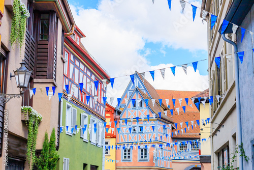 Canvastavla Colorful flags hang over narrow streets in a historic town during a local festiv