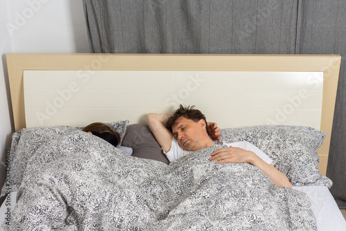Fotografía A fifty-year-old couple sleeps side by side in their bedroom at night