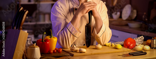 Male chef with knife cuttin...