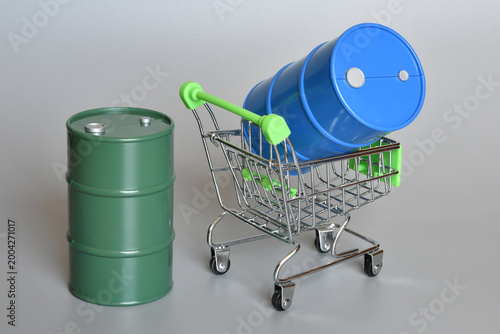 Miniature oil barrels on a shopping cart. Concept of shortage and rising fuel prices due to the Middle East crisis and the war in Iran.