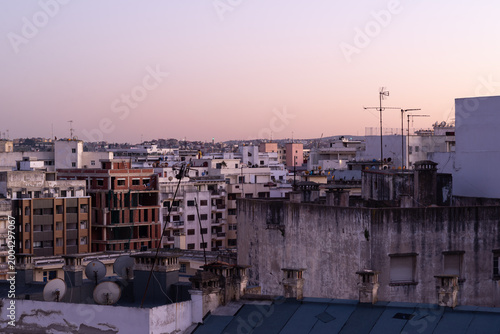Skyline of Tangier at sunset with purple and orange sky, Morocco.