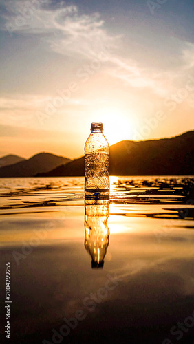 plastic bottle floating on calm reflective water surface
