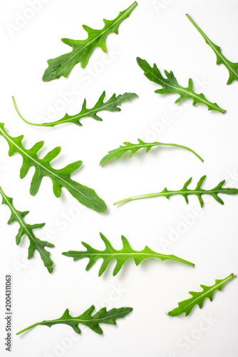 Arugula leaves pattern on white background, fresh green texture, top view