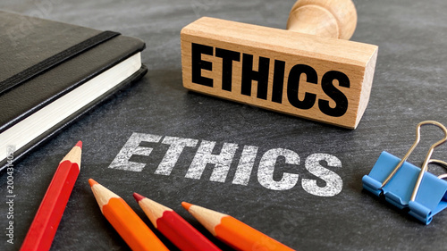 A prominent wooden stamp displaying the bold word 'ETHICS' signifies the crucial importance of moral principles for corporate integrity and professional conduct.