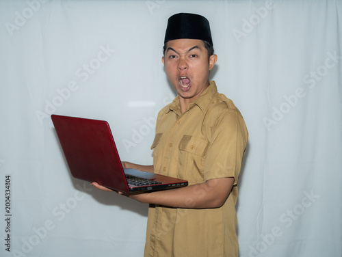 Quadro su tela A male Indonesian civil servant (PNS) wears a traditional hat and a beige shirt
