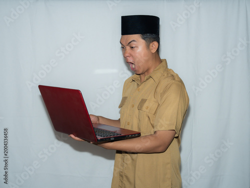 Quadro em tela A male Indonesian civil servant (PNS) wears a traditional hat and a beige shirt