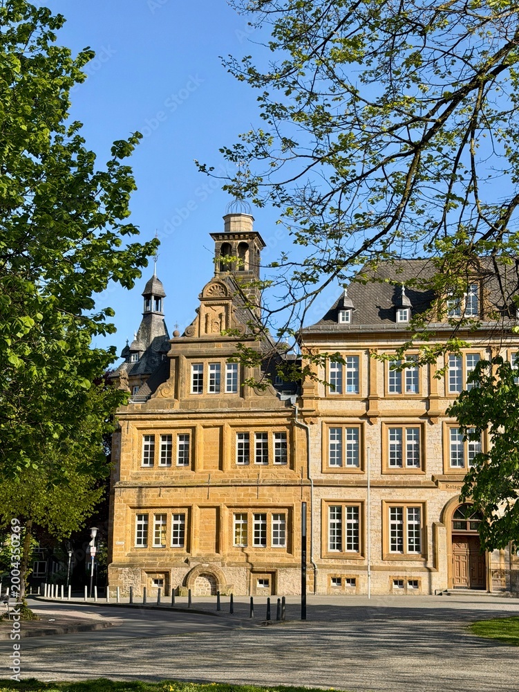 Fototapeta premium Beautiful historic building with ornate facade and tower under blue sky
