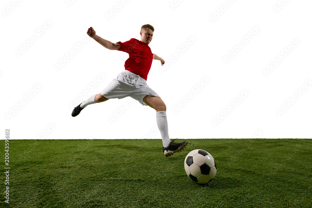 Obraz premium Soccer player jumping to strike ball on grass field against white background. Concept of football action, training promo, sports event banner, athlete campaign and tournament advertising.