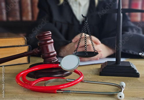 Konstfotografi Judge and medical tools on a desk with legal books in the background