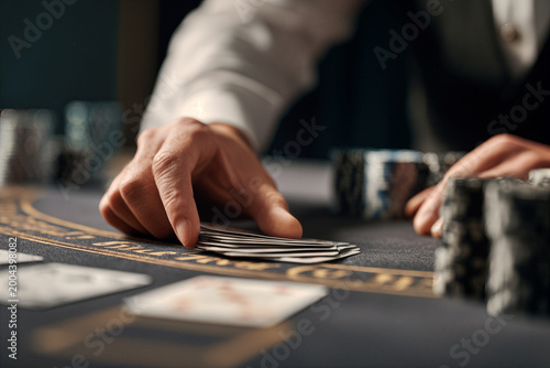 Dealer's Hand in Tense Casino Moment with Poker Chips and Cards on