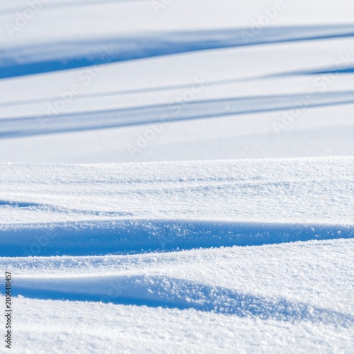 Fresh white snow texture with soft blue shadows, rolling drifts and sparkling crystals, ideal for winter season backgrounds and weather reports