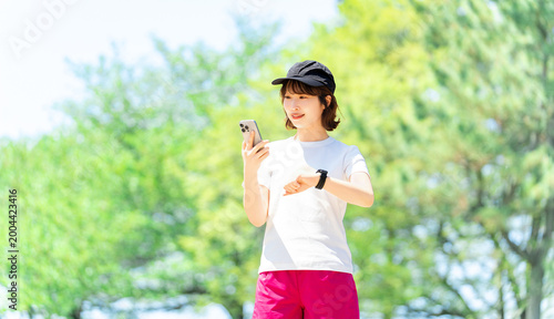 スマートフォンとスマートウォッチを確認する女性のライフスタイルイメージ, Woman Checking Smartphone and Smartwatch Lifestyle Concept