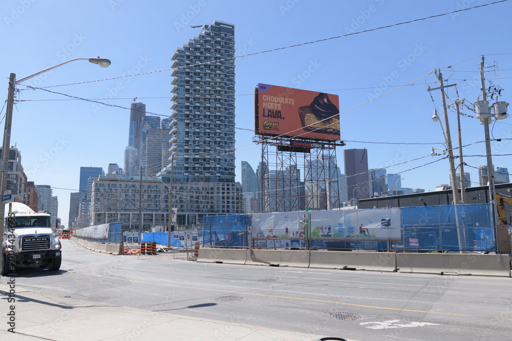 Fototapeta premium roadside tower billboard for candy and distant view of Monde Condominiums, looking west on Queens Quay E, Toronto