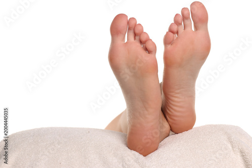 Fotografie Close-up of a woman’s bare feet resting on a towel with clean smooth skin, concept of footcare and wellness, studio shot on a white background