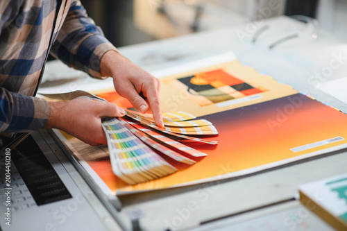 Canvas Print Print worker checking color swatches at factory press