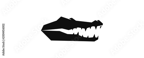 Silhouette of crocodile head with open mouth against black background
