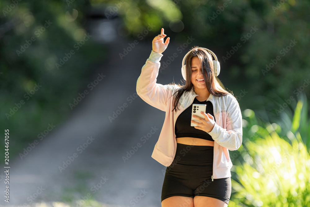 Obraz premium Young woman enjoying music outdoors moving to rhythmic sounds