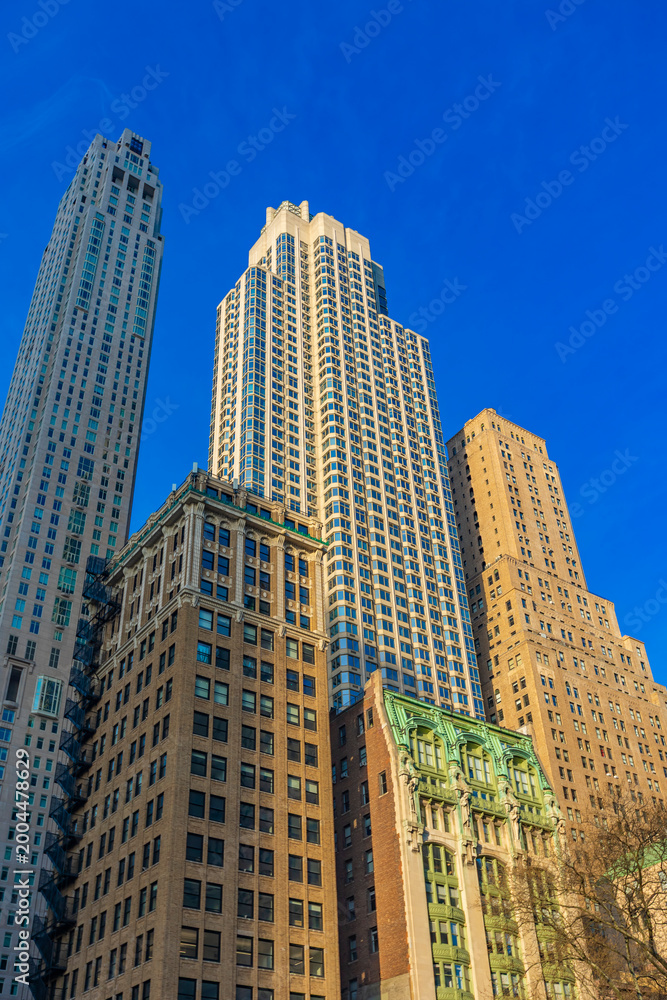 Fototapeta premium Skyscrapers touching the sky in vibrant Lower Manhattan during midday