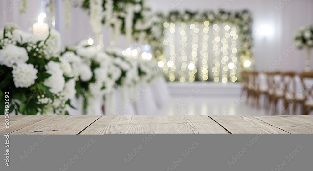 Obraz premium Empty wooden table surface in front of a blurry summer garden with flowers and bright soft sunlight